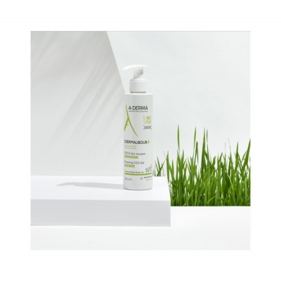 Frasco do produto A-DERMA DERMAFLUOR 3 CICA GEL MOUSSE sobre superfície branca com grama verde