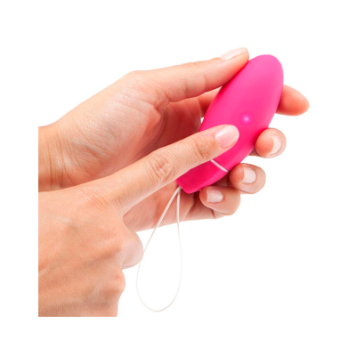 Dispositivo eletrônico pequeno rosa com botão e cordão branco segurado por duas mãos