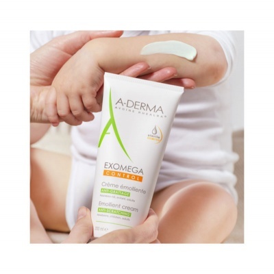 Frasco de creme A-DERMA EXOMEGA CONTROL a ser aplicado no braço de uma criança