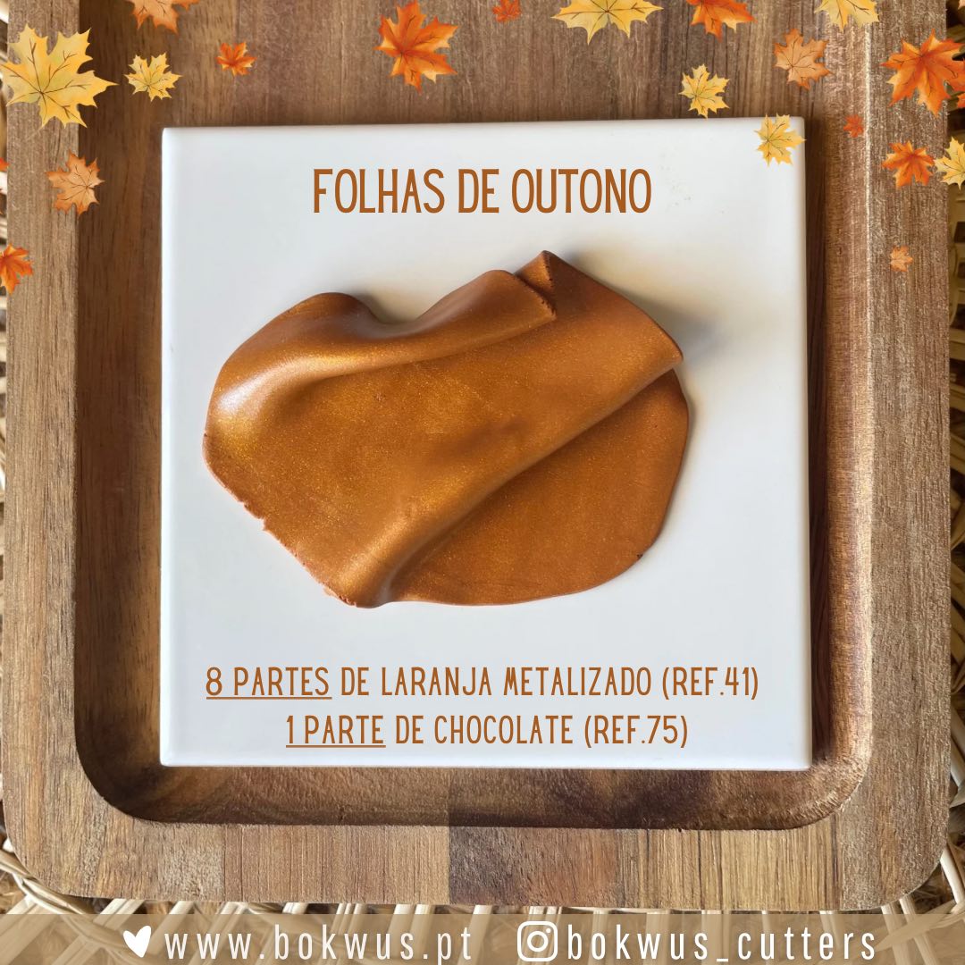 Molde ou amostra de tons castanho metálico com texto 'FOLHAS DE OUTONO' e referências de cores sobre base branca em superfície de madeira com folhas outonais.