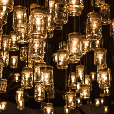 Candeeiros suspensos de vidro com luzes quentes num teto escuro