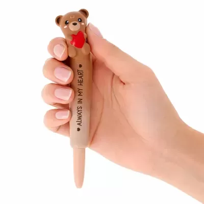 Caneta com pega em forma de urso castanho segurando coração vermelho e texto ALWAYS IN MY HEART no corpo