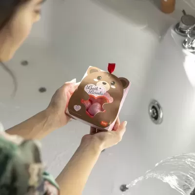 Pacote com design de urso castanho contendo bombas de banho cor-de-rosa