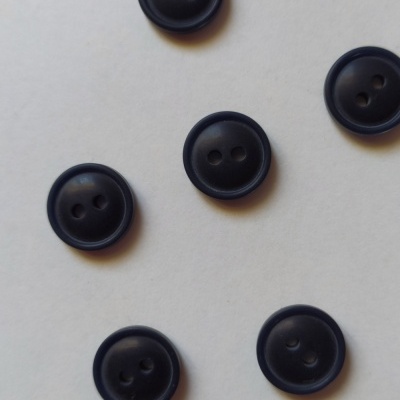 Botões pretos redondos com dois furos sobre fundo branco