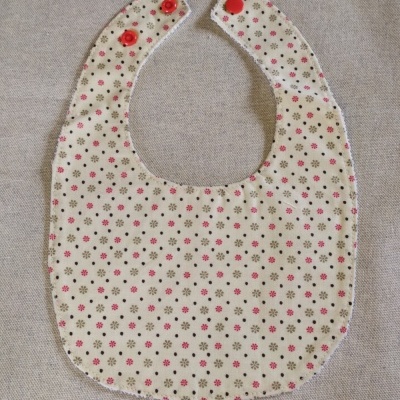 Babete floral com fecho vermelho em fundo cinzento