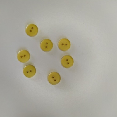 Botões amarelos redondos com dois orifícios sobre fundo branco