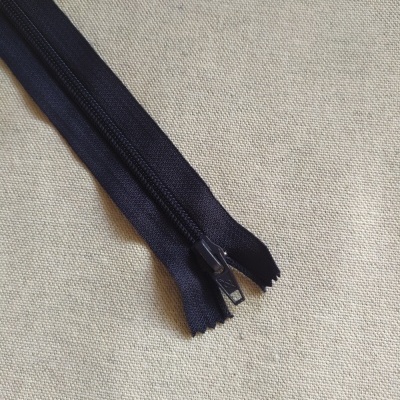 Fecho éclair preto sobre tecido bege claro com texto Cor 730