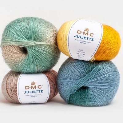 Quatro novelos de lã D.M.C. Juliette em cores variadas com etiquetas brancas.