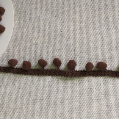 Fita decorativa castanha com bolas em tecido castanho sobre fundo cinzento claro com texto 'Castanho'