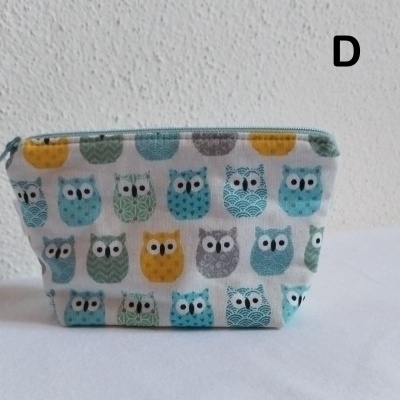 Necessaire de tecido com padrão de corujas coloridas e fecho azul.