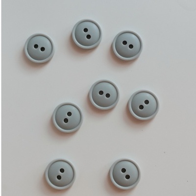 Oito botões cinza redondos com dois furos sobre fundo branco