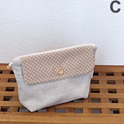 Bolsa pequena de tecido cinzento claro com aba rosa claro e padrão de bolinhas brancas