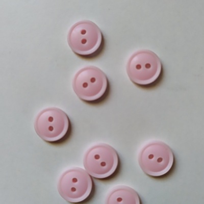 sete botões rosas claros com dois furos sobre fundo branco