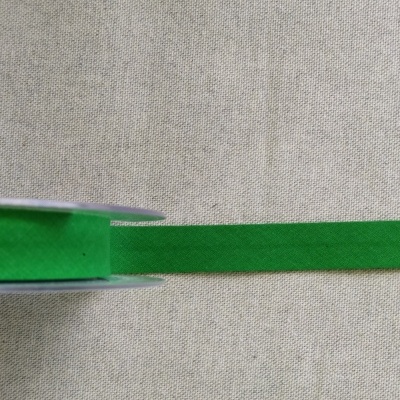 Fita verde de tecido em rolo sobre fundo bege com texto Cor 15