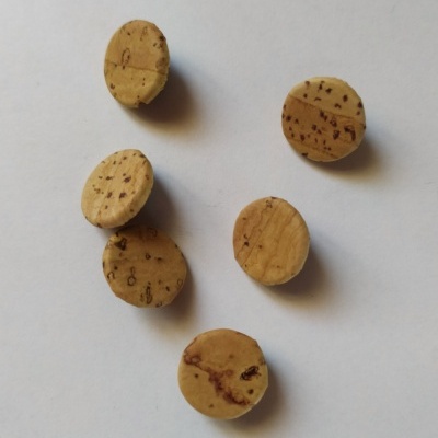 Seis rolhas redondas de cortiça com manchas sobre fundo branco com texto 15 mm