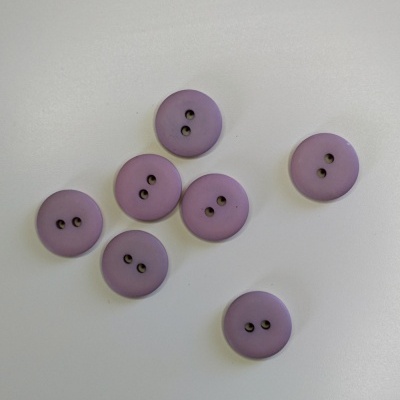 Botões lilás redondos com dois furos sobre superfície branca