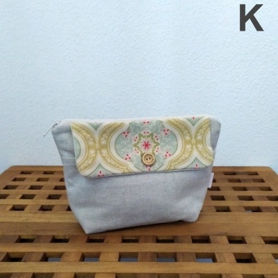 Bolsa pequena de tecido cinzento com aba decorativa e botão de madeira