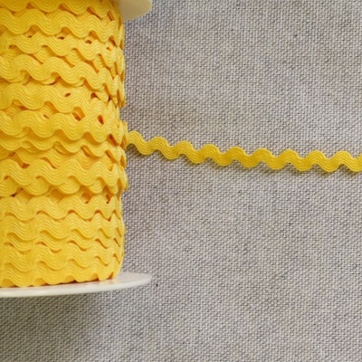 Rolo de fita amarela zigzag contra fundo bege