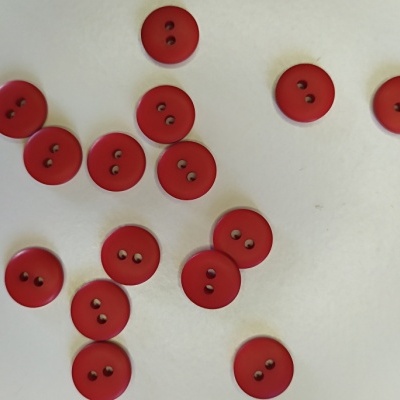 Botões vermelhos redondos com dois orifícios sobre fundo branco