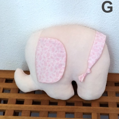 Almofada em forma de elefante cor-de-rosa com orelha estampada e laço na cauda