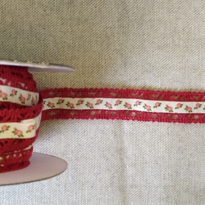 Fita decorativa com padrão de flores em fundo creme e borda vermelha