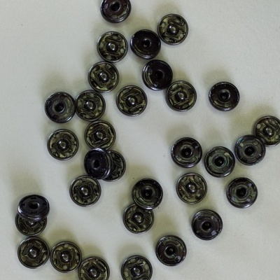 Botões pretos redondos de plástico sobre superfície branca