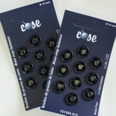 Cartelas com botões de pressão pretos em cartaz azul escuro