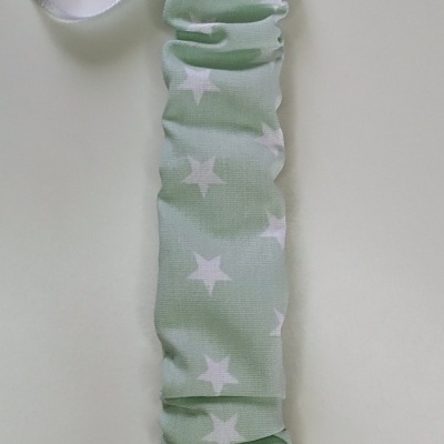 Porta-chupeta verde claro com estrelas brancas e clipe branco