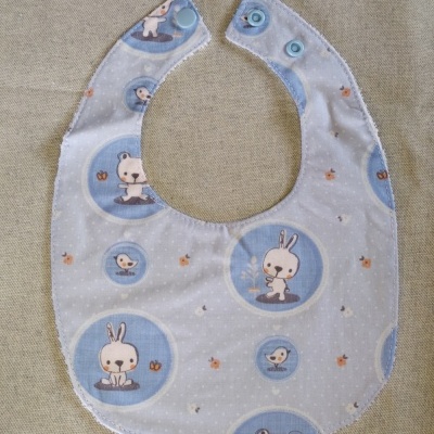 Babete para bebé com padrão de coelhos, ursos e pássaros em círculos azuis
