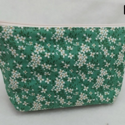 Necessaire verde com padrão de flores brancas e fecho branco