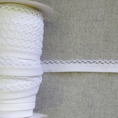 Rolo de fita rendada branca sobre fundo cinzento