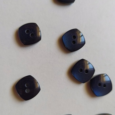 Botões quadrados arredondados pretos com dois buracos sobre fundo branco