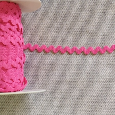 Rolo de fita zig-zag rosa sobre fundo cinzento com texto 'Rosa'