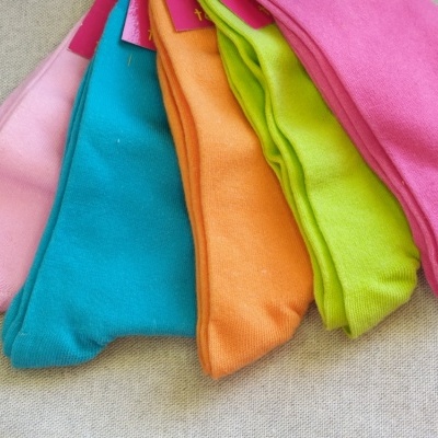 Meias coloridas em várias cores sobre superfície cinza