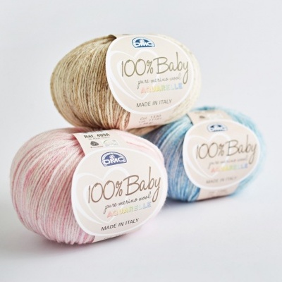 Três novelos de lã merino para bebé em bege, azul e rosa com etiquetas DMC 100% Baby