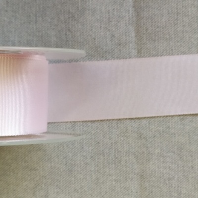 Fita de tecido rosa claro desenrolada sobre fundo cinzento com texto Rosa Claro