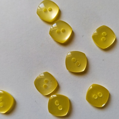 Botões quadrados amarelos translúcidos com dois orifícios, em fundo branco