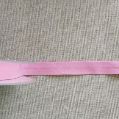 Rolo de fita rosa clara sobre tecido bege com texto Cor 7