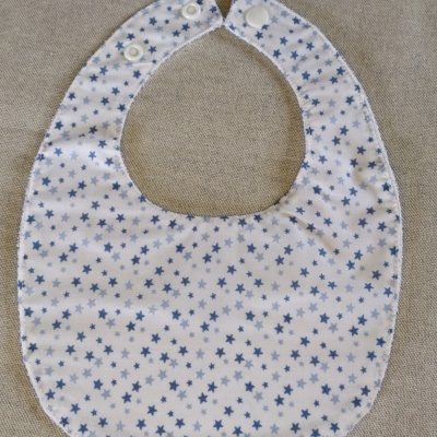 Babete branco com padrão de estrelas azuis e fecho de pressão