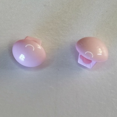 Dois botões rosa com desenho branco sobre superfície branca