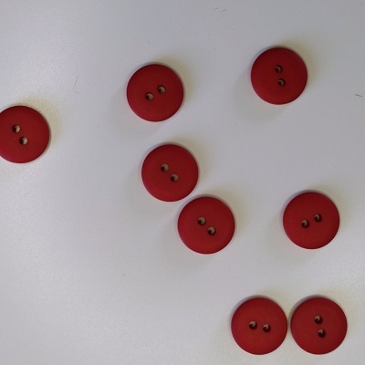 Oito botões vermelhos redondos com dois furos sobre fundo branco