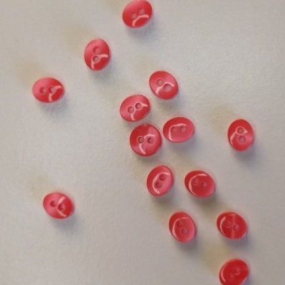 Botões vermelhos pequenos com dois furos em superfície branca