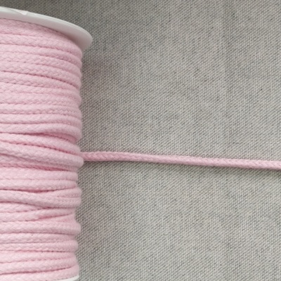 Carretel de cordão de algodão rosa sobre fundo cinzento com a palavra ROSA