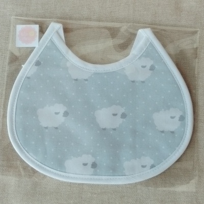 Babete azul claro com estampado de ovelhas em embalagem transparente