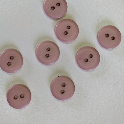 Oito botões rosa claros com dois furos, sobre fundo branco