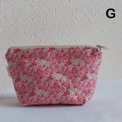 Necessaire de tecido rosa com flores brancas e vermelhas e fecho branco