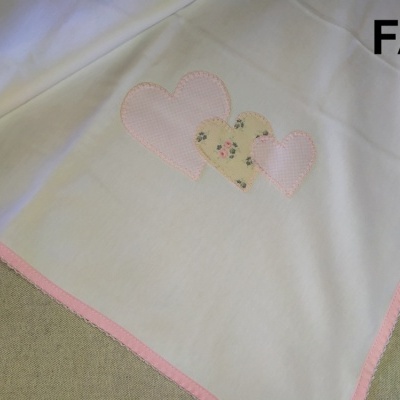 toalha branca com borda rosa e corações aplicados, etiqueta FA6