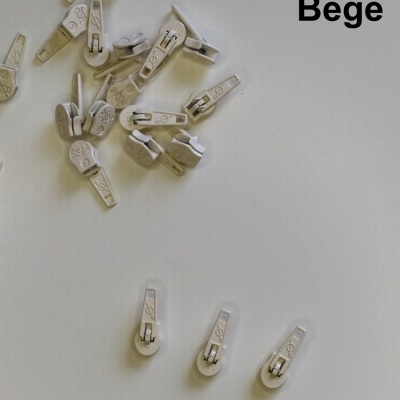 Puxadores de fecho éclair bege em plástico sobre superfície branca com texto 'Bege'