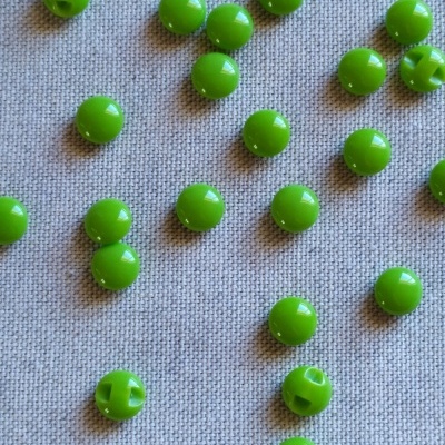 Contas redondas verdes em tecido cinza com texto 'Verde'