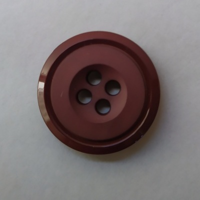 Botão castanho com quatro buracos sobre fundo branco